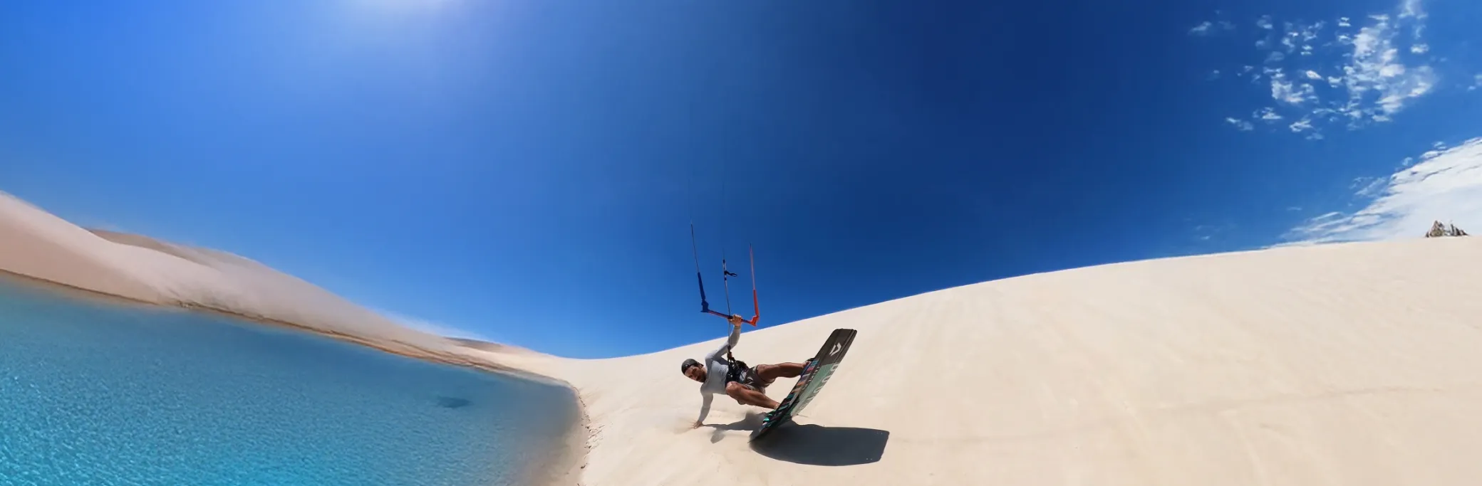 Atleta praticando kite surf nas dunas com lagoa